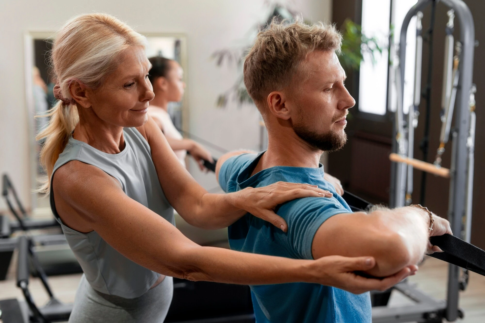An osteopath assessing the shoulder and spine of a seated client from behind