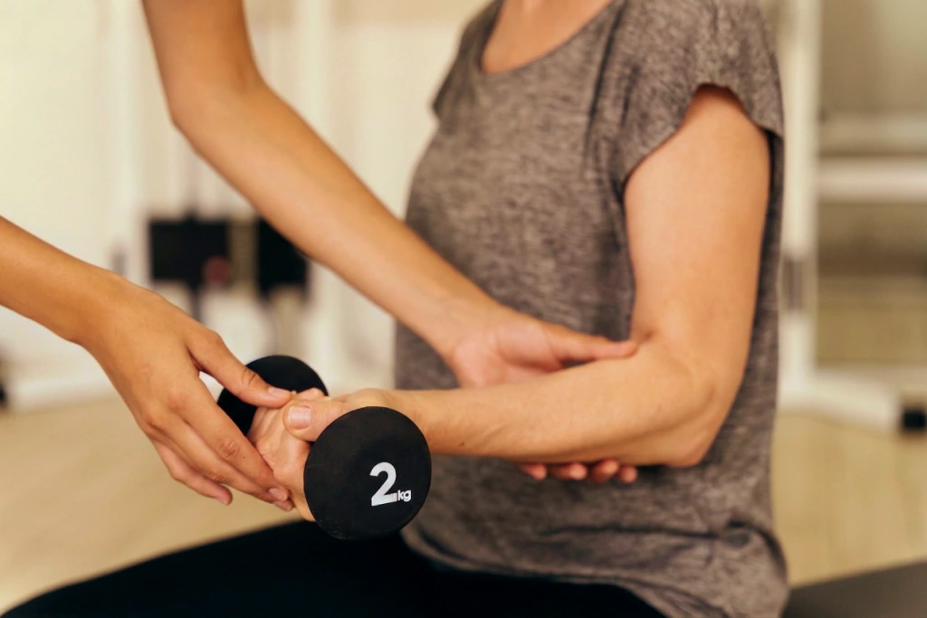 An osteopath applying a hands-on technique to a patient's forearm